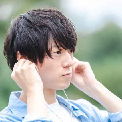 外出時にイヤホンで耳を塞ぎ環境音が聞こえず不安な様子